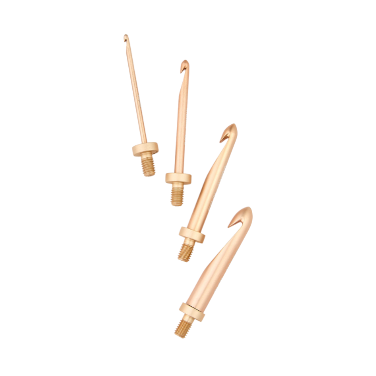Set of rose gold crochet hooks on a white background