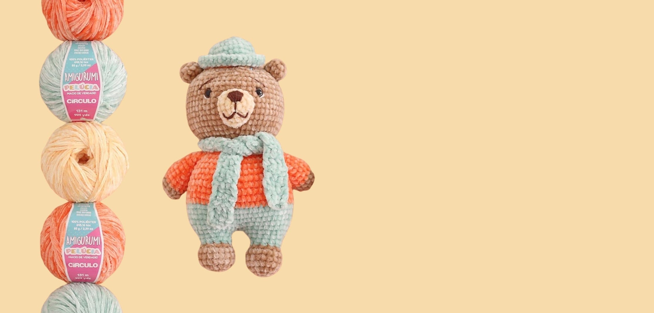 Crocheted teddy bear with yarn balls on a beige background