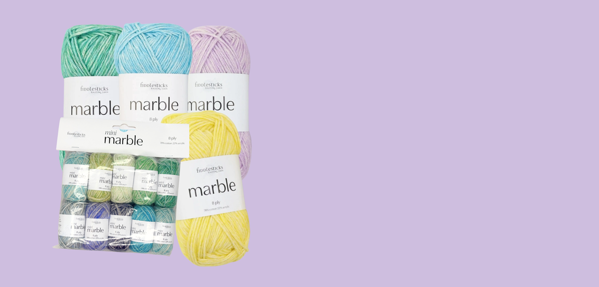 A set of Marble yarn skeins in assorted pastel and bright colors, including mint green, sky blue, lavender, yellow, and teal, arranged on a solid light purple background.